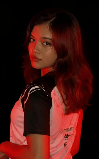 A portrait of LEIRA, Creative Nexus Lead for DKLT Designs, wearing a white E-sports jersey.